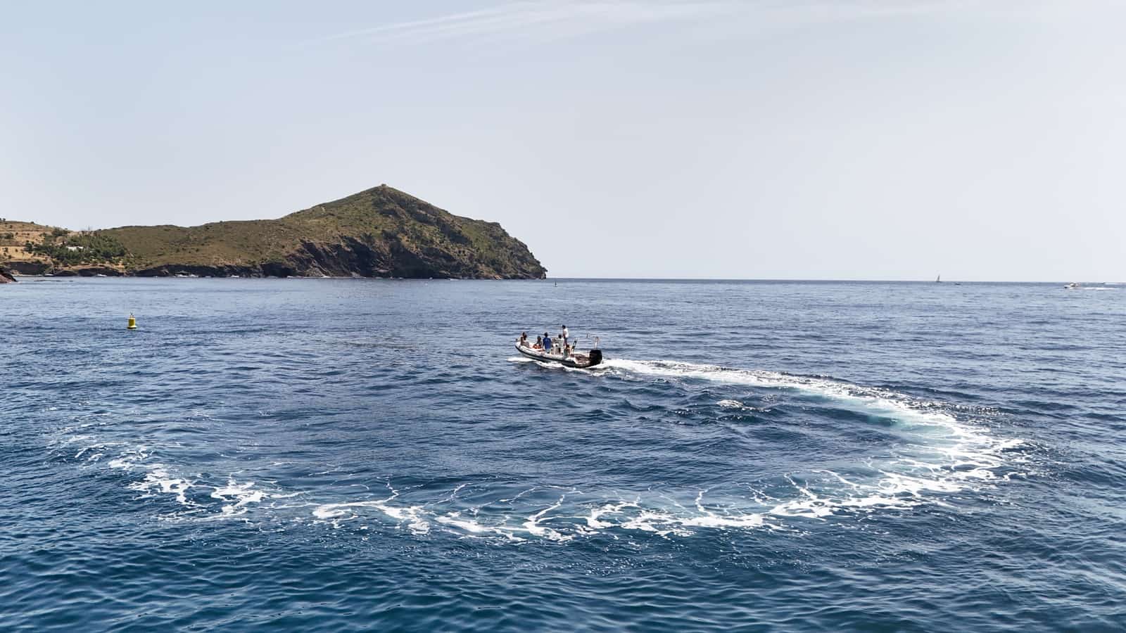 Barco navegando por las calas del Cap de Creus desde Roses, Costa Brava